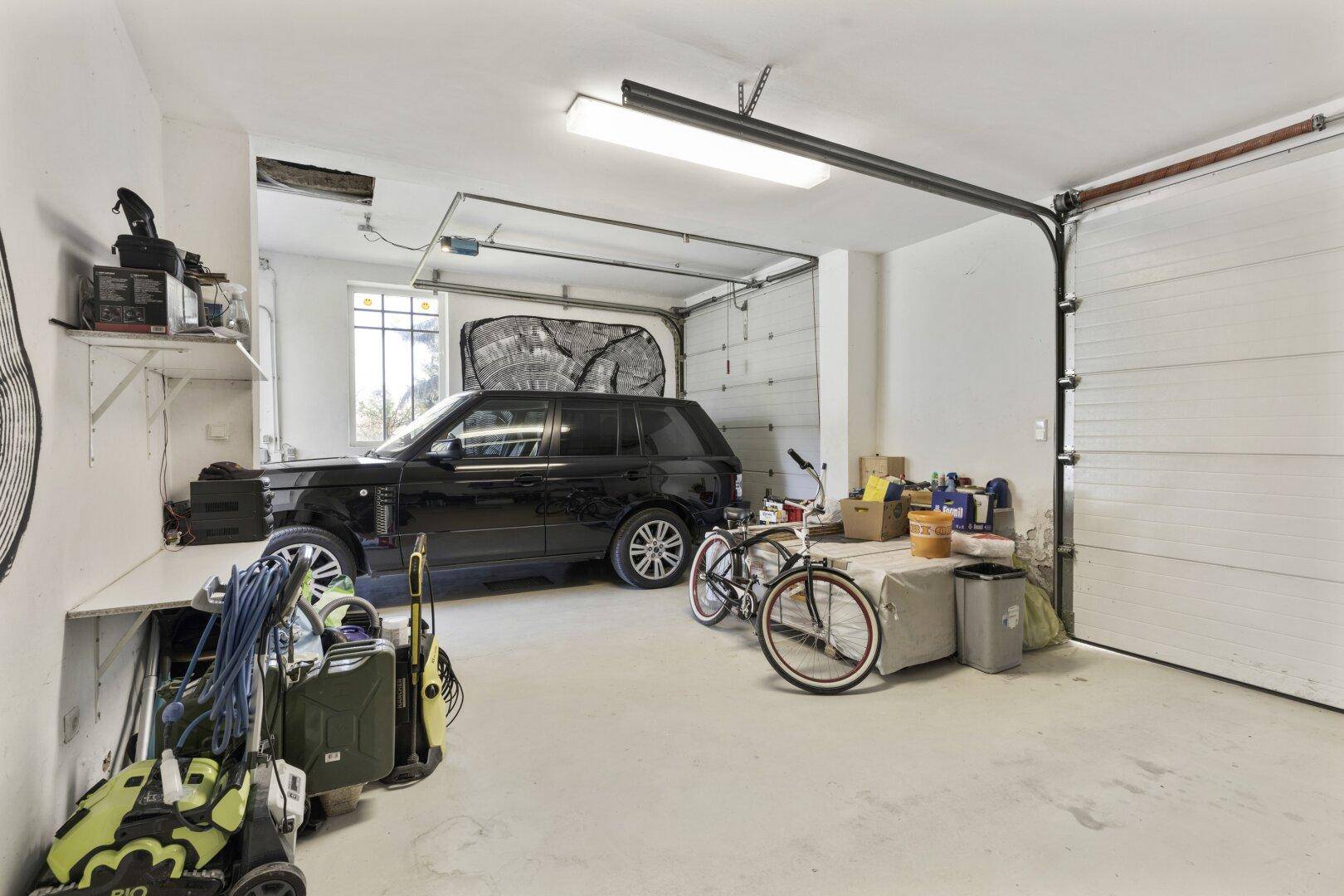 Geräumige Garage mit Platz für ein Fahrzeug, Fahrräder und Abstellflächen.