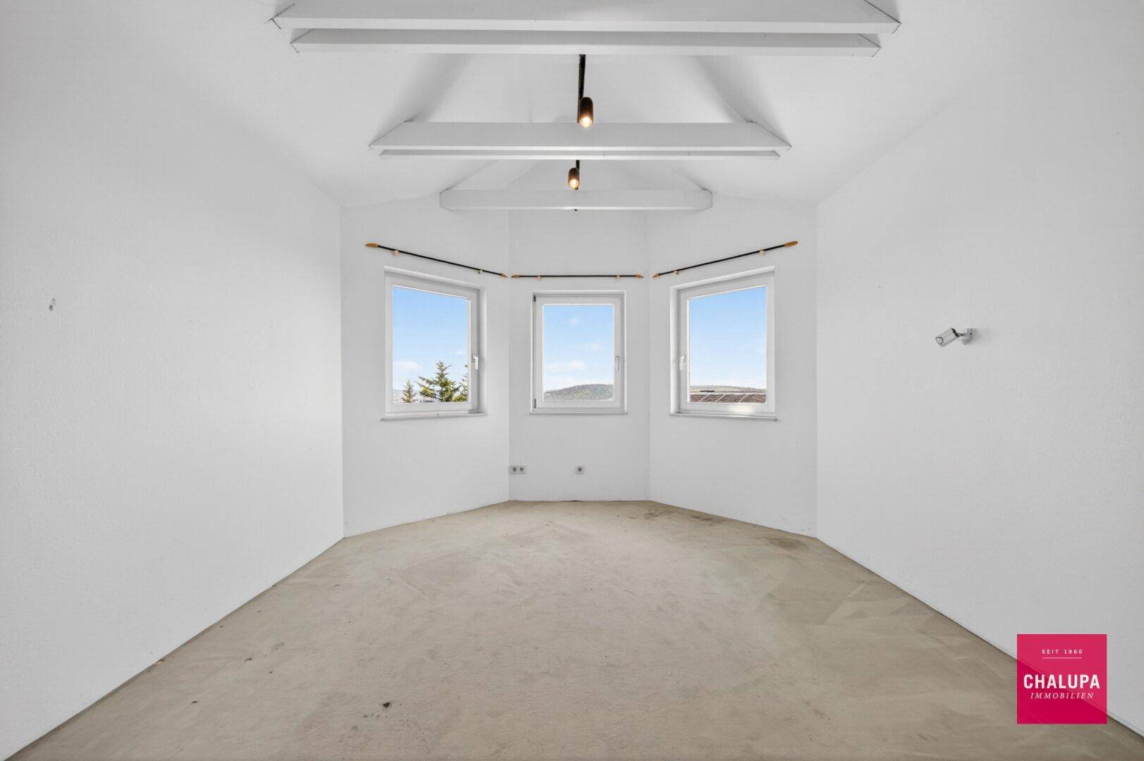 Helles Zimmer mit Teppichboden und Erkerfenstern, ideal als Schlaf- oder Arbeitszimmer.