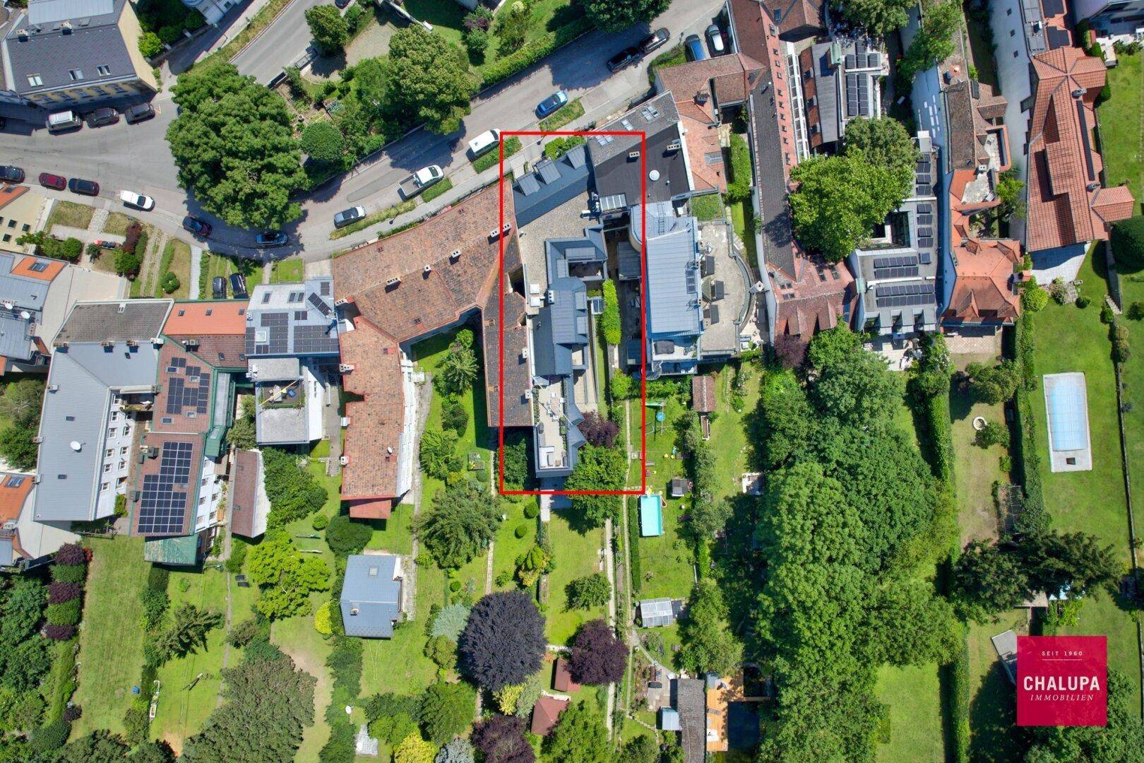 Luftaufnahme des Wohngebiets mit markierten Grundstücksgrenzen und umliegenden Häusern.