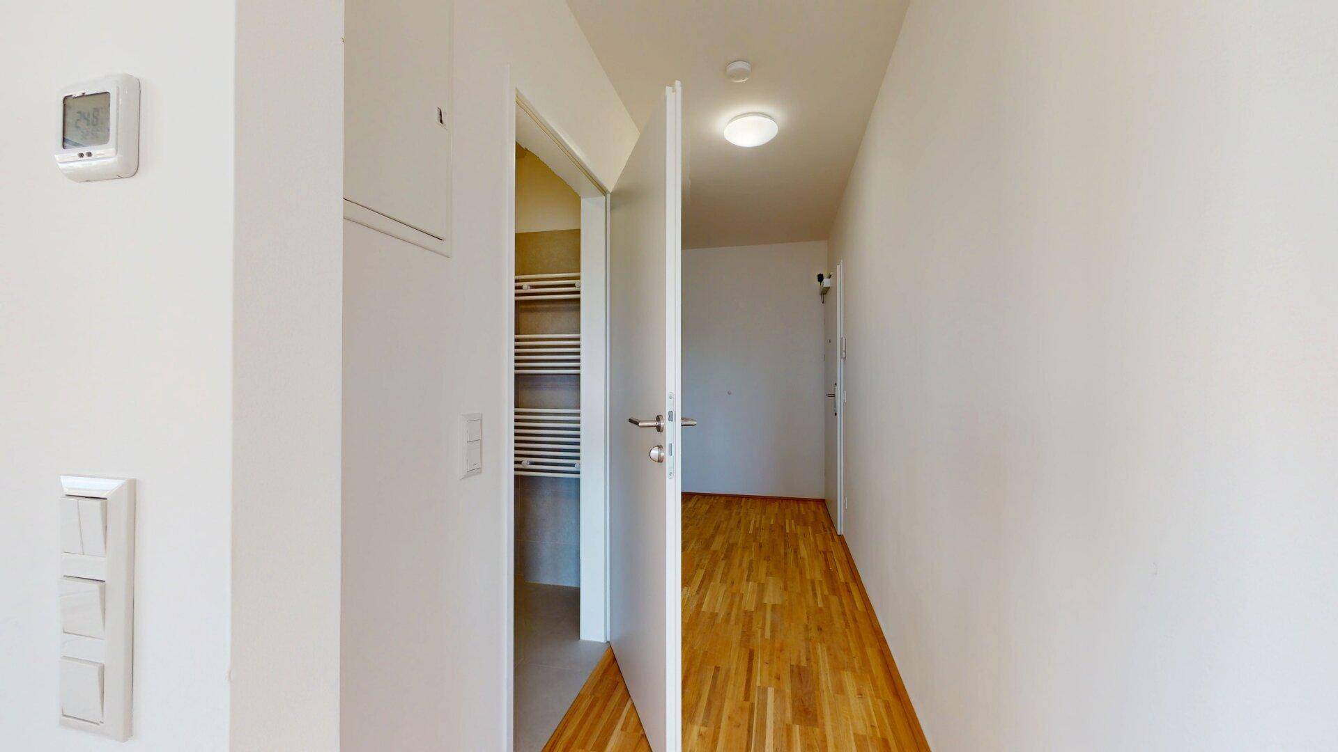 Heller Flur mit Parkettboden und Zugang zu weiteren Räumen der Wohnung.
