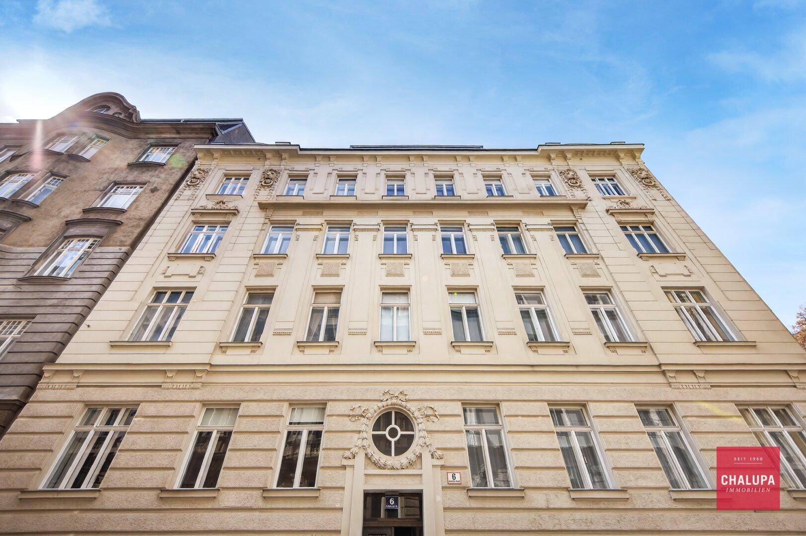 Klassische, reich verzierte Fassade eines historischen Gebäudes mit vielen Fenstern.