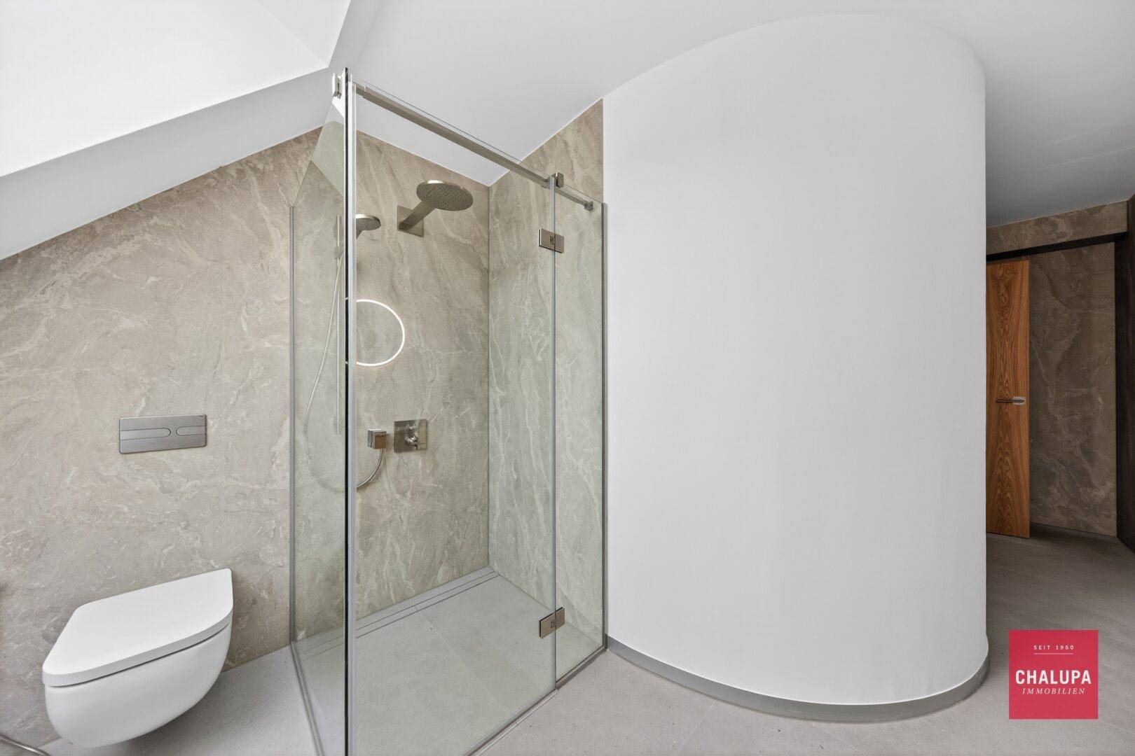 Elegantes Badezimmer mit begehbarer Dusche, Wand-WC und modernen Fliesen.