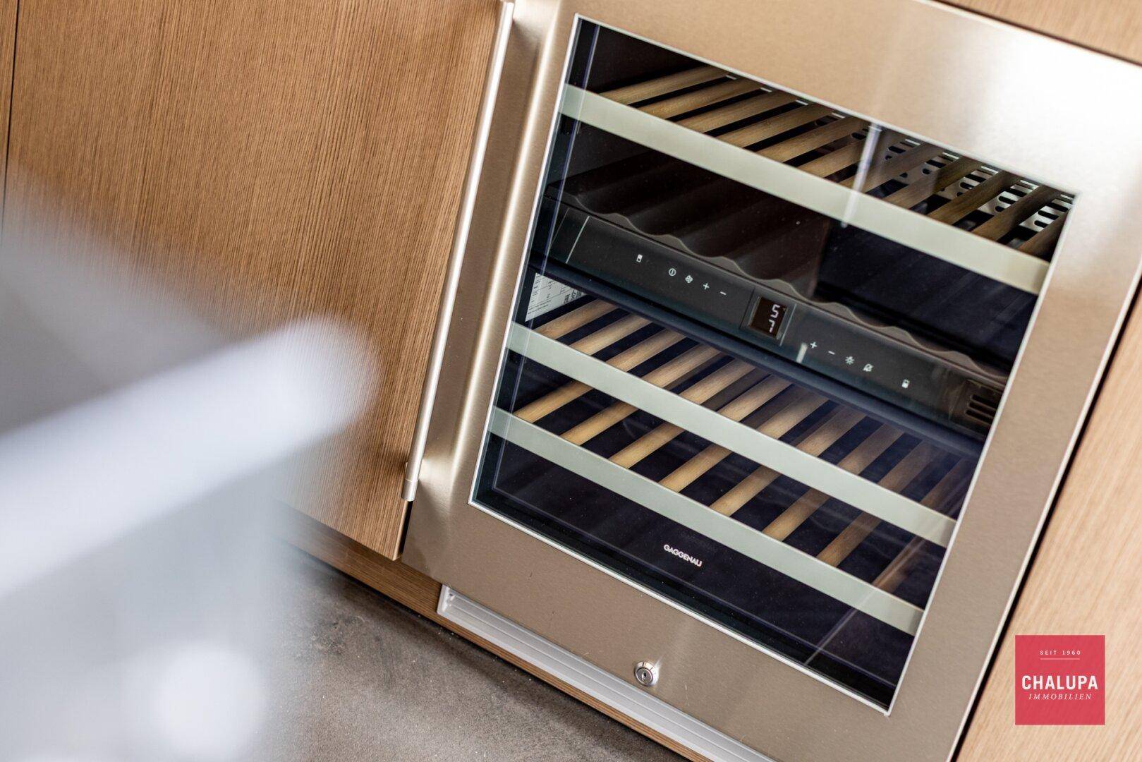 Detailaufnahme eines integrierten Weinkühlers in einer modernen Holzküche.