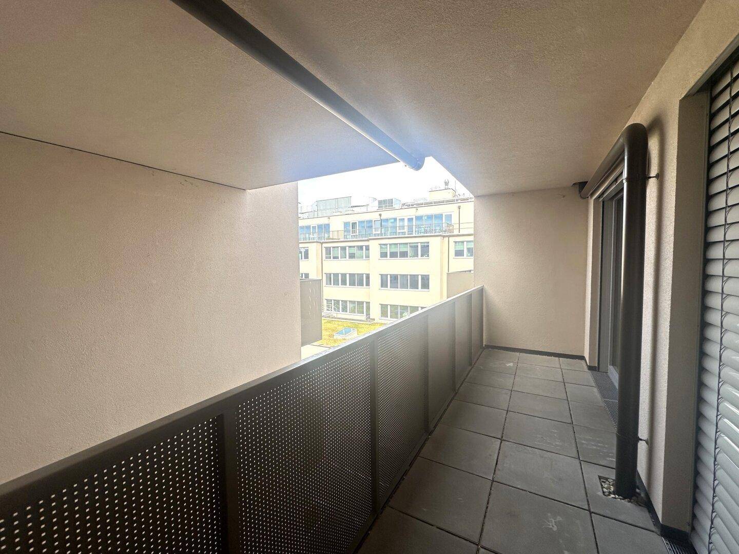 Langer, schmaler Balkon mit Blick auf umliegende Gebäude und Stadtansicht.