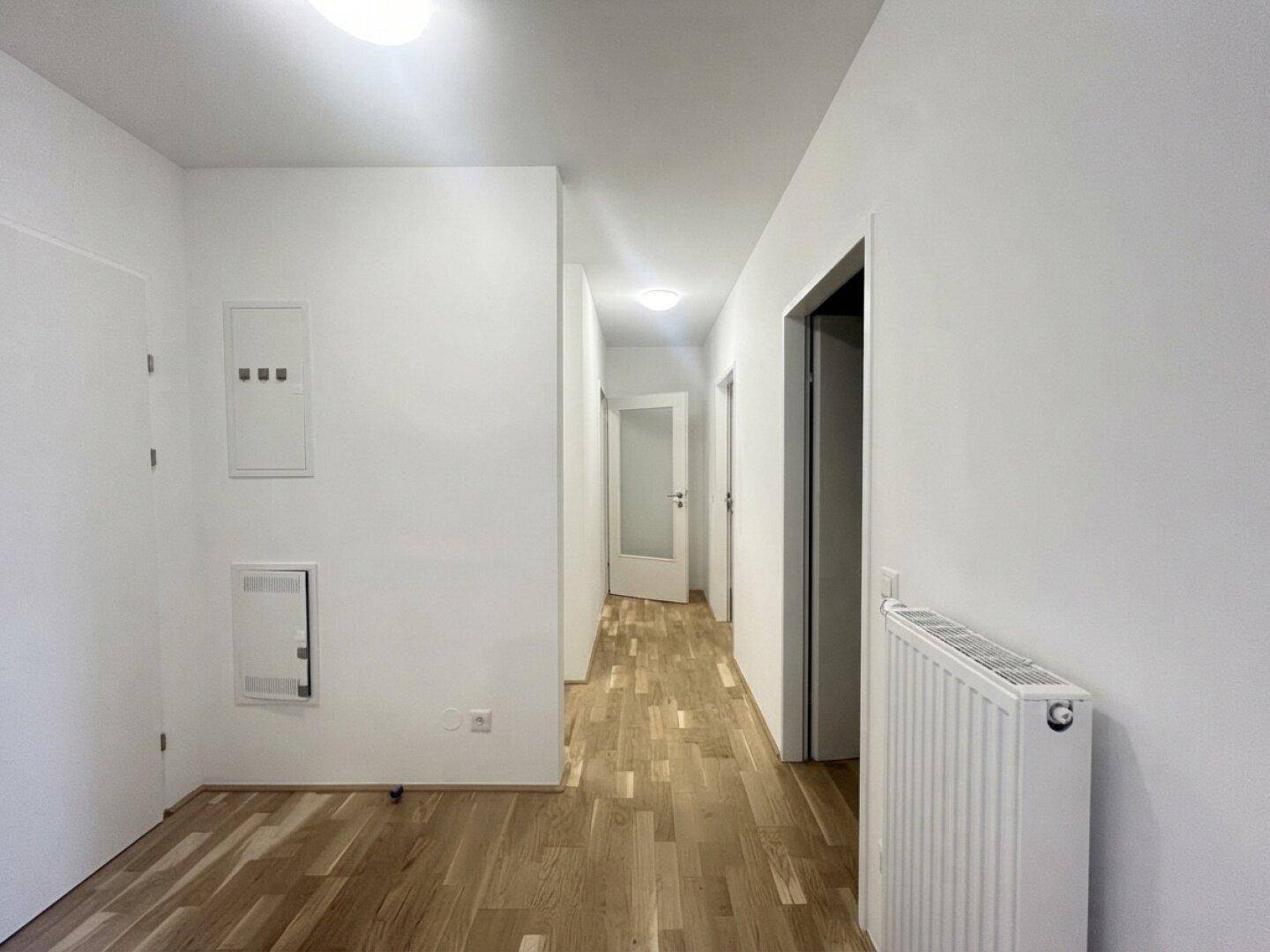 Heller Flur mit Parkettboden und Zugang zu verschiedenen Räumen der Wohnung.