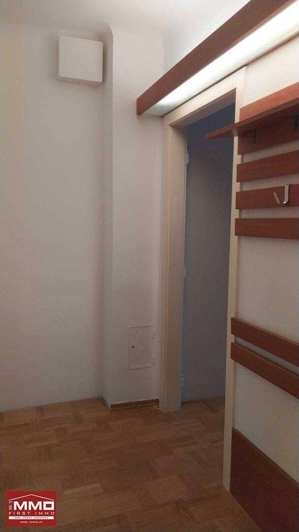 Flur mit Parkettboden und praktischer Garderobe aus Holz.