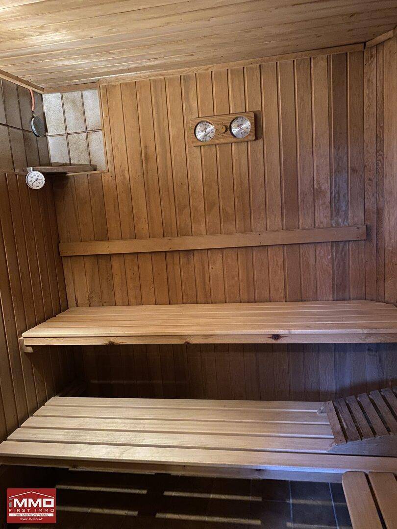 Innenansicht einer Holzsauna mit Bänken und Temperaturanzeigen für Entspannung.