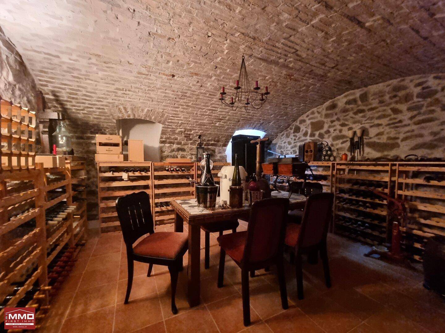 Historischer Weinkeller mit Gewölbedecke, Weinregalen und Verkostungsbereich für Liebhaber.