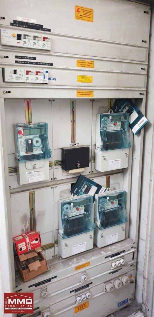 Elektrischer Zählerkasten mit mehreren Stromzählern und Sicherungen, ordentlich installiert für das Gebäude.