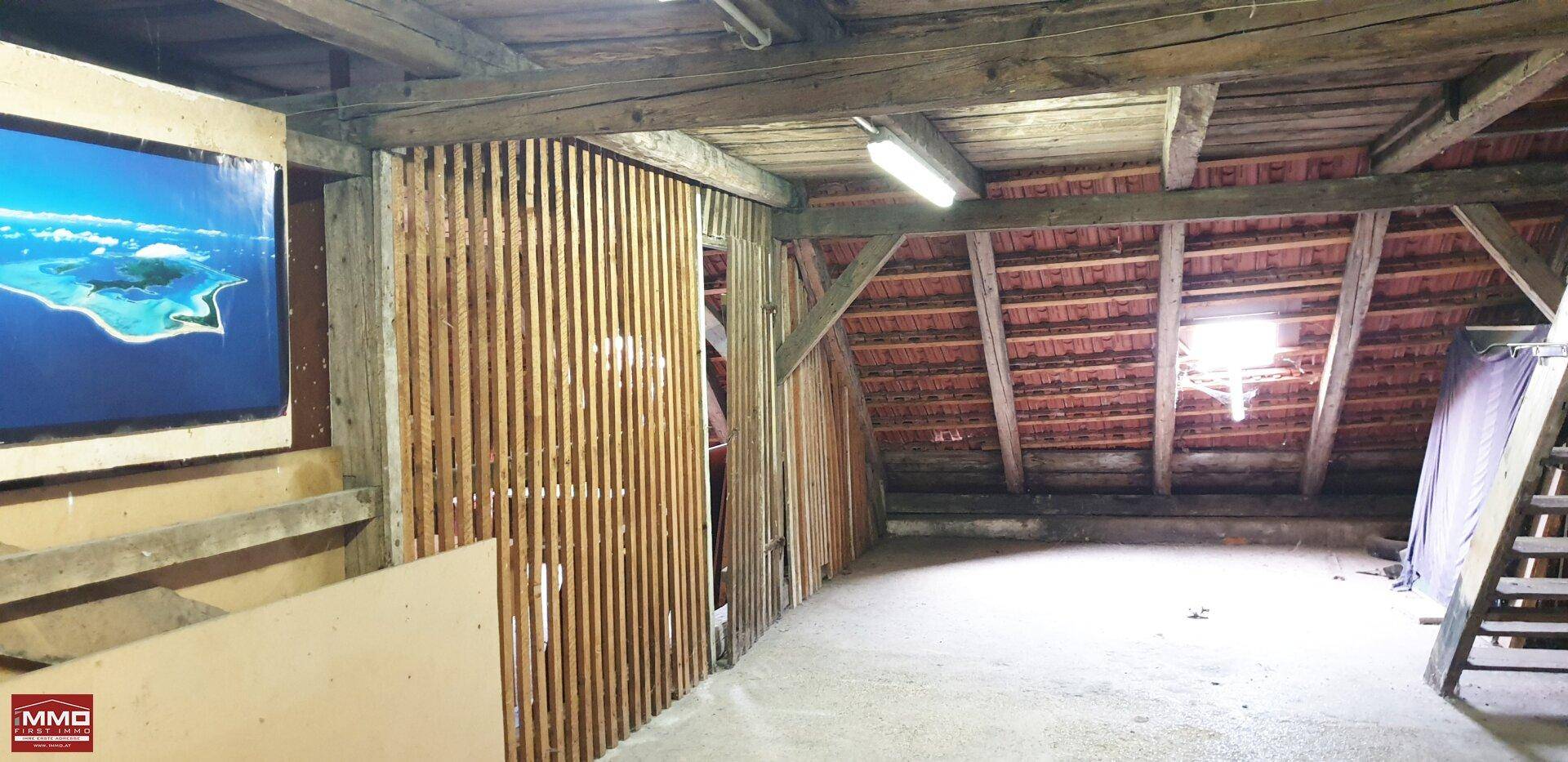Geräumiger Dachboden mit sichtbaren Holzbalken und Dachziegeln, bietet viel Potenzial für zukünftigen Ausbau.