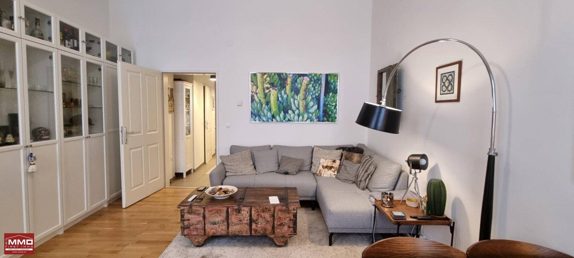 Gemütliches Wohnzimmer mit großem Ecksofa, Holztruhe als Couchtisch und Einbauschränken.