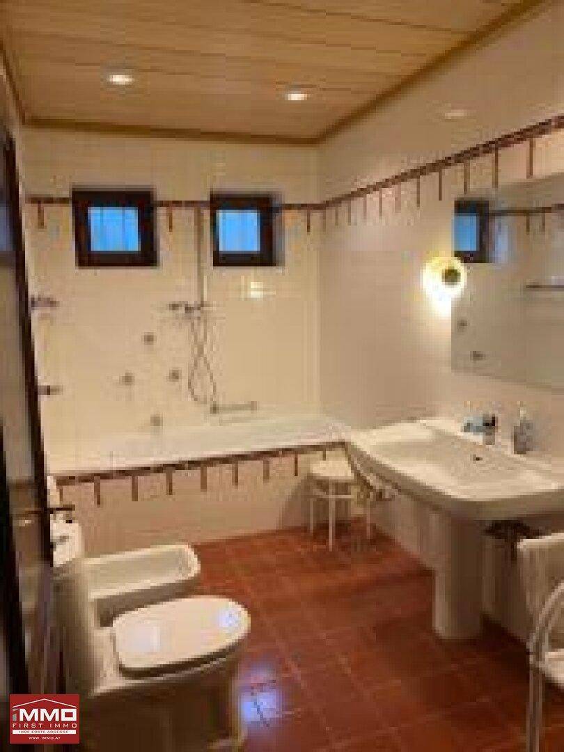 Funktionales Badezimmer mit Badewanne, Bidet und zwei Fenstern, charakteristisch für die 80er Jahre.