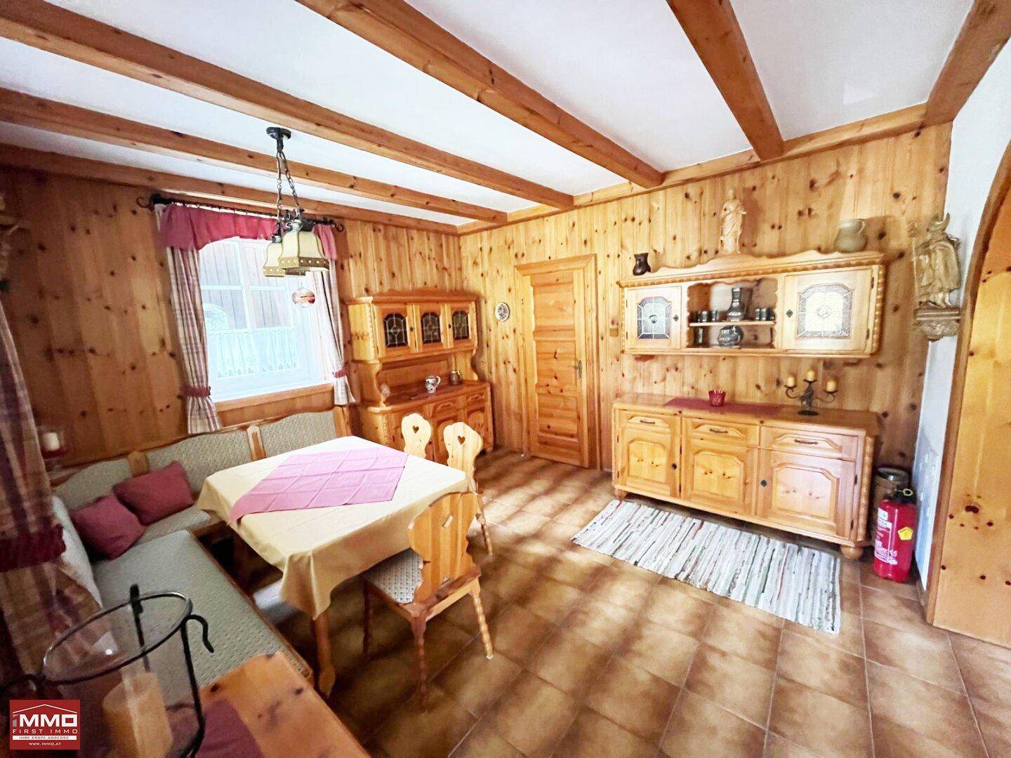 Gemütlicher Essbereich im alpinen Stil mit Holzvertäfelung, Holzbalken und traditionellen Möbeln.