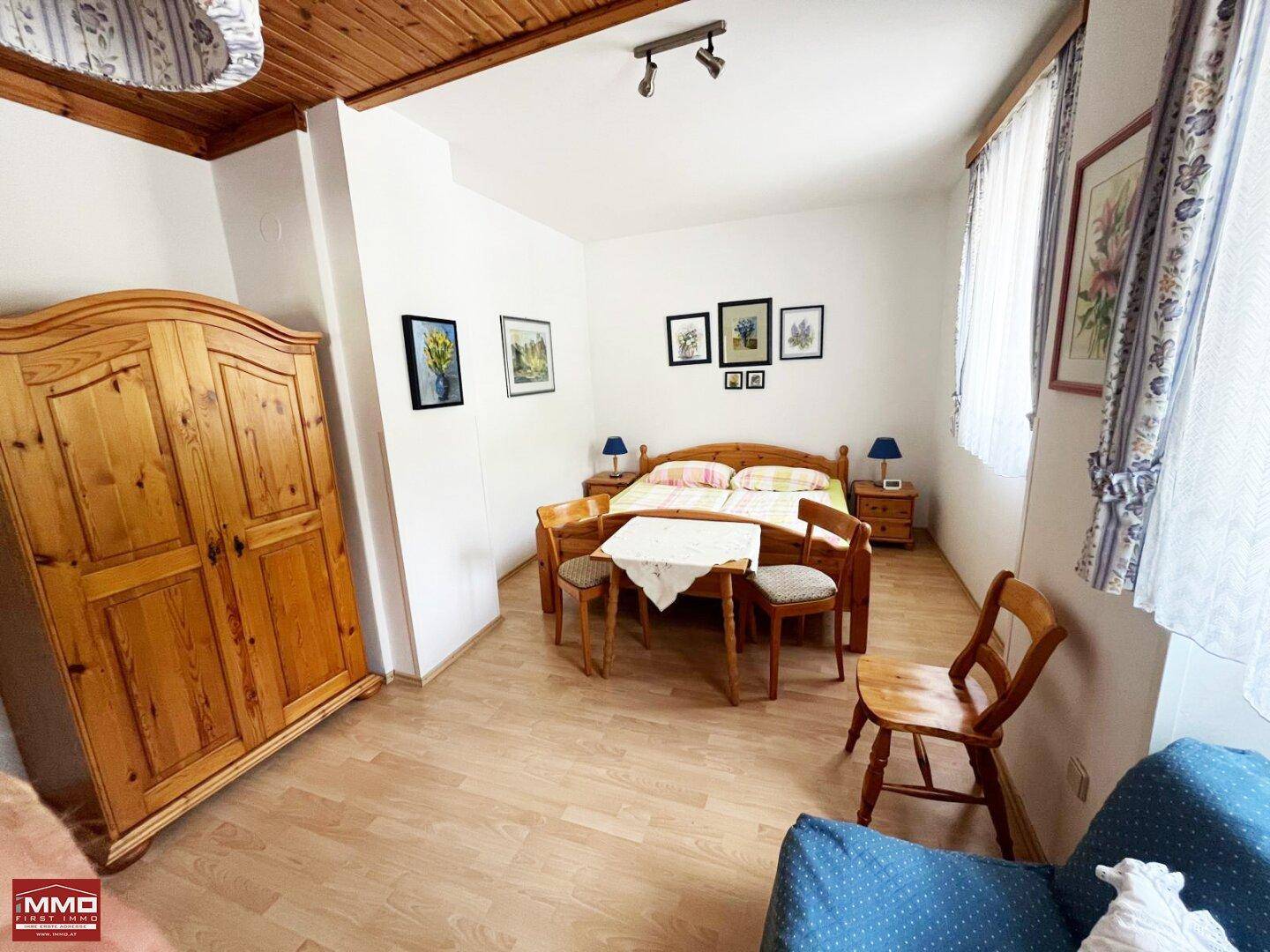 Helles Schlafzimmer mit Holzboden, Holzbalken und traditionellen Holzmöbeln.