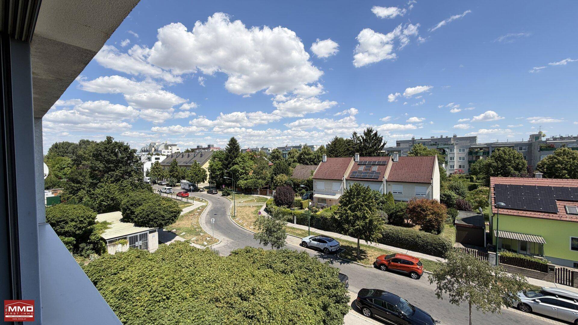 Weitläufiger Ausblick von der Loggia auf die grüne Wohngegend mit Einfamilienhäusern.