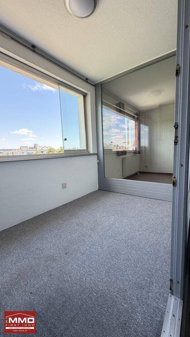 Verglaste Loggia mit Teppichboden und weitem Blick in die Umgebung.