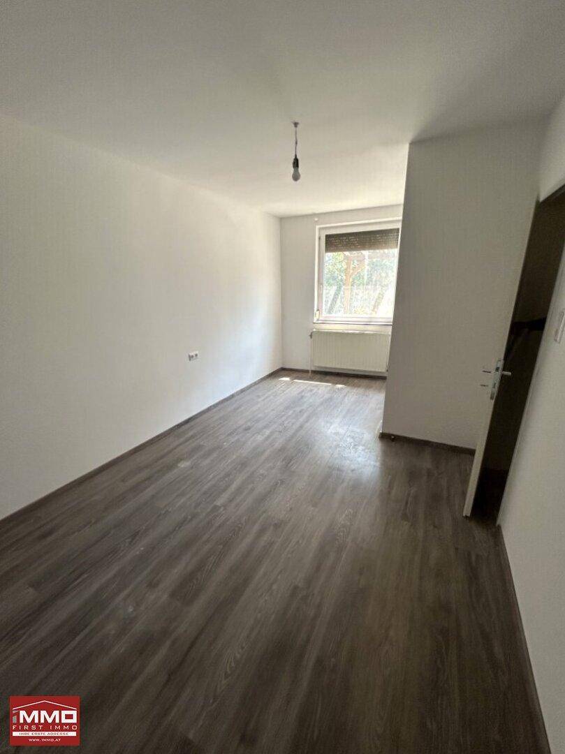 Freundliches Zimmer mit neuwertigem Laminatboden und weiß gestrichenen Wänden.