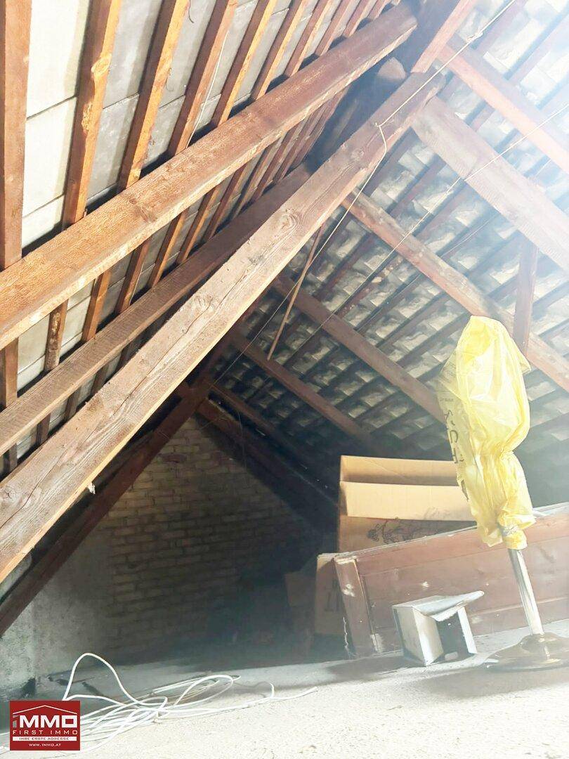 Dachboden mit sichtbaren Holzbalken und schräger Dachkonstruktion, ideal als Stauraum.