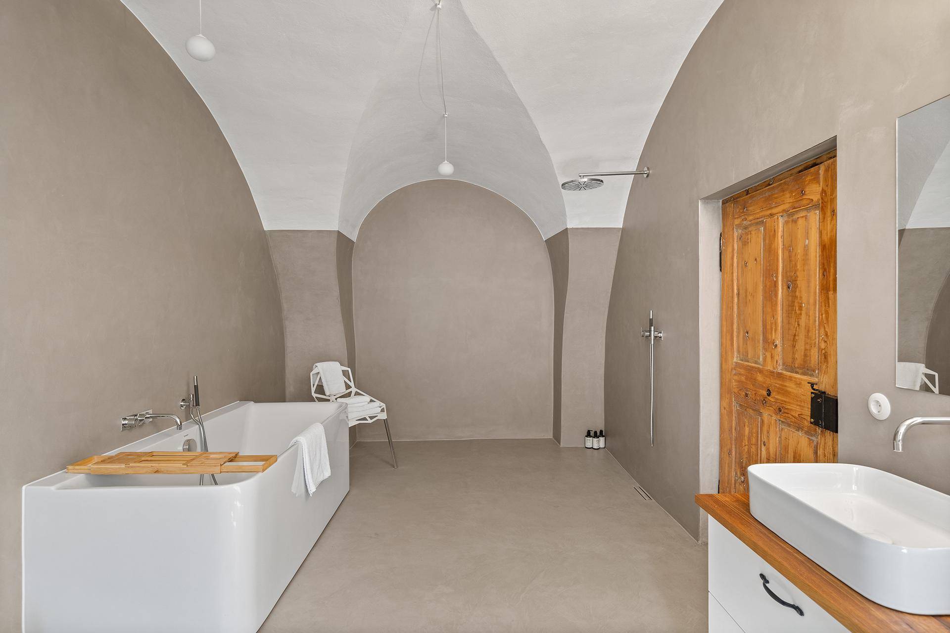 Modernes Badezimmer mit freistehender Badewanne, begehbarer Dusche und Gewölbedecke.