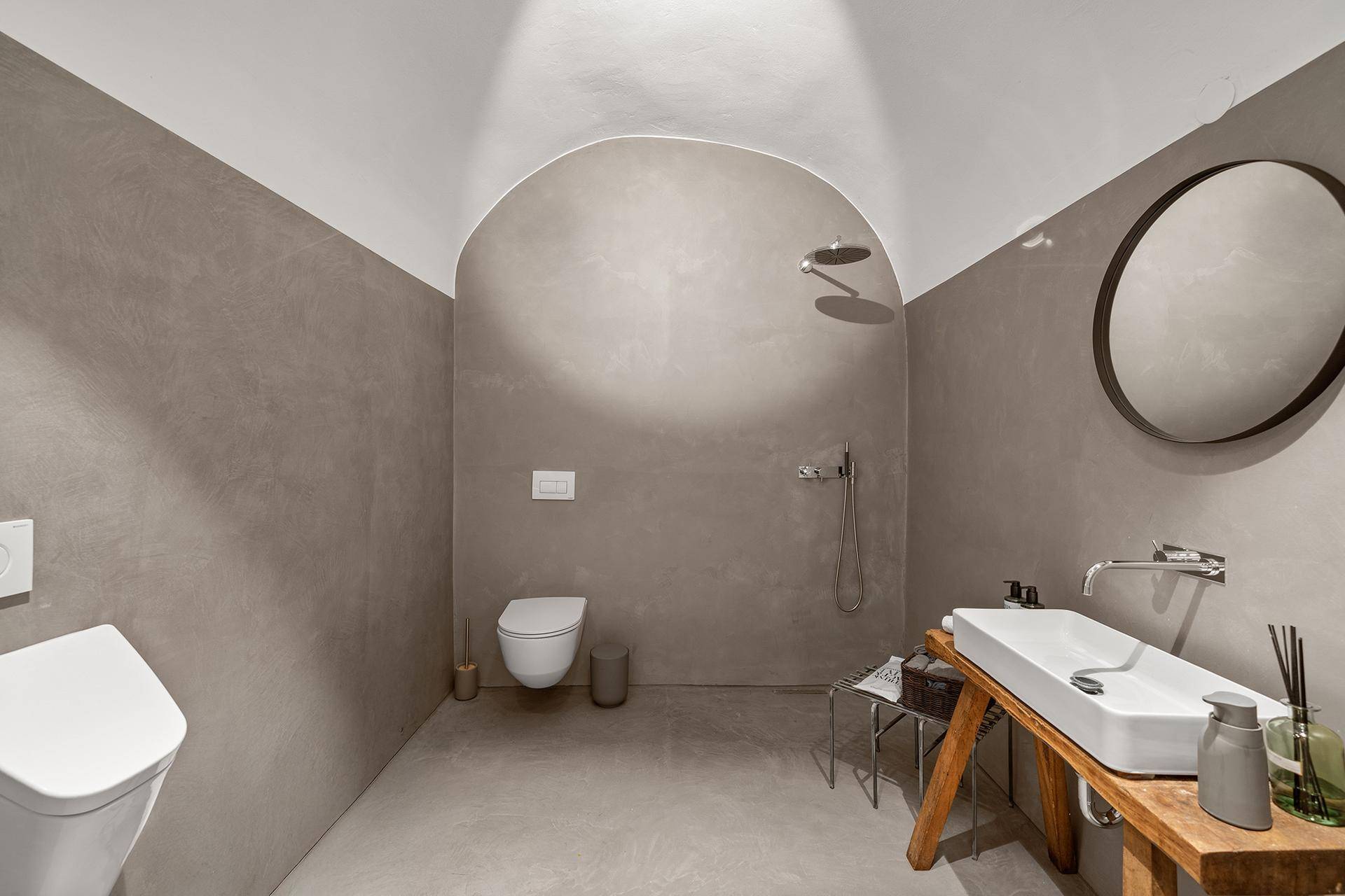 Elegantes Badezimmer mit Gewölbedecke, begehbarer Dusche und modernem Waschtisch.