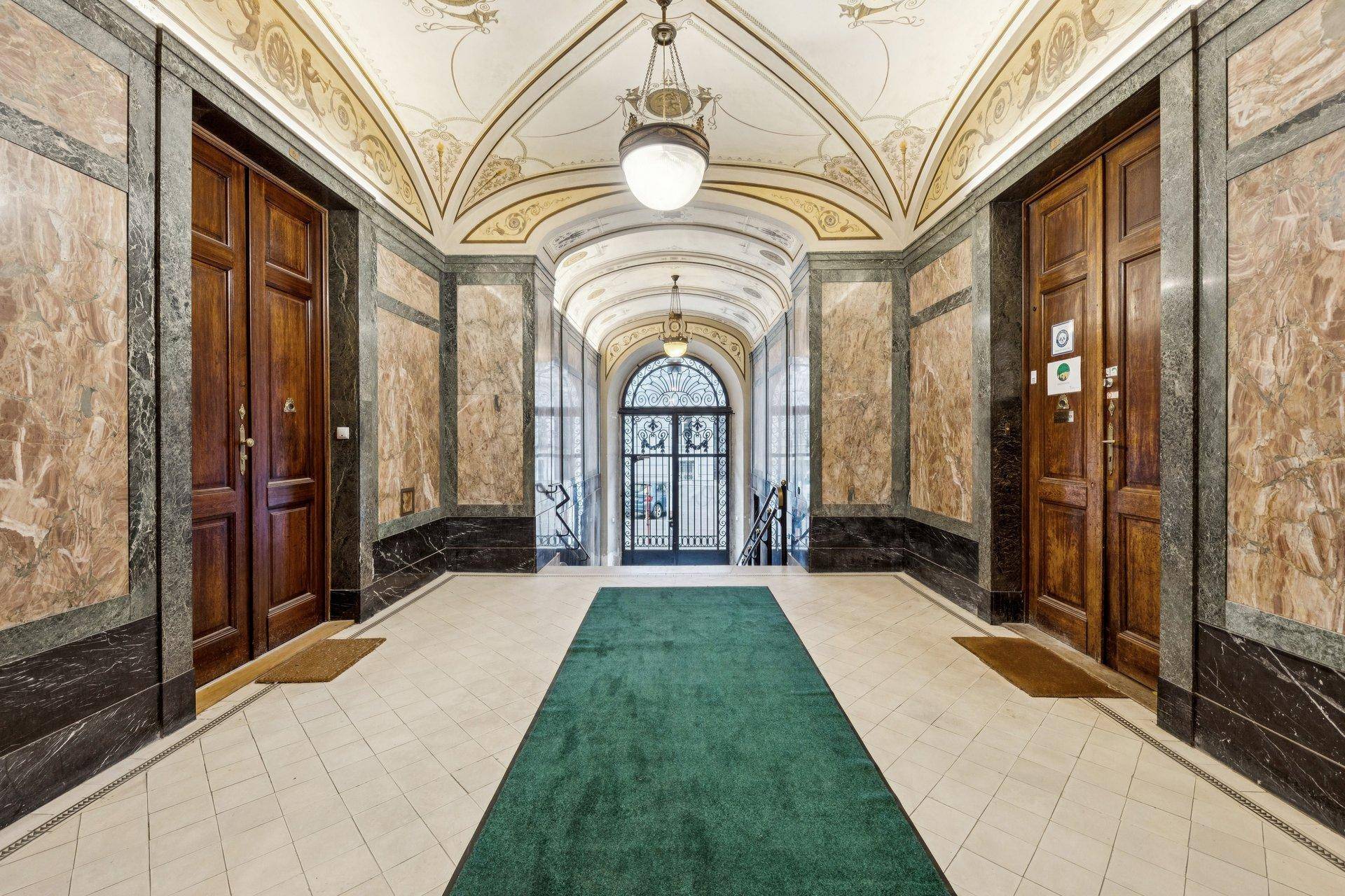 Prunkvoller Eingangsbereich mit Marmorverkleidung, Stuckdecken und historischen Türen.