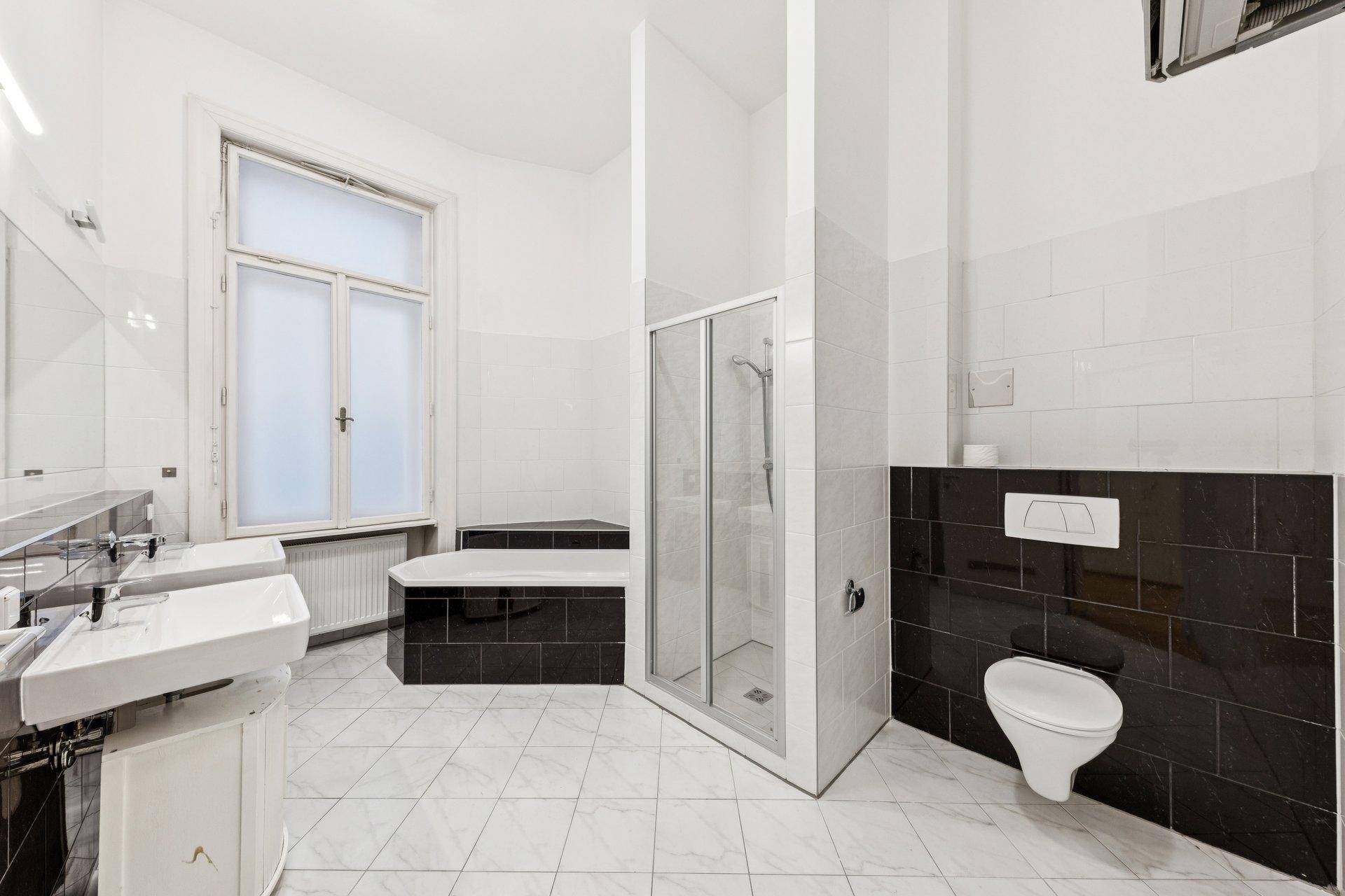 Geräumiges Badezimmer mit Doppelwaschbecken, Badewanne, Dusche und WC.