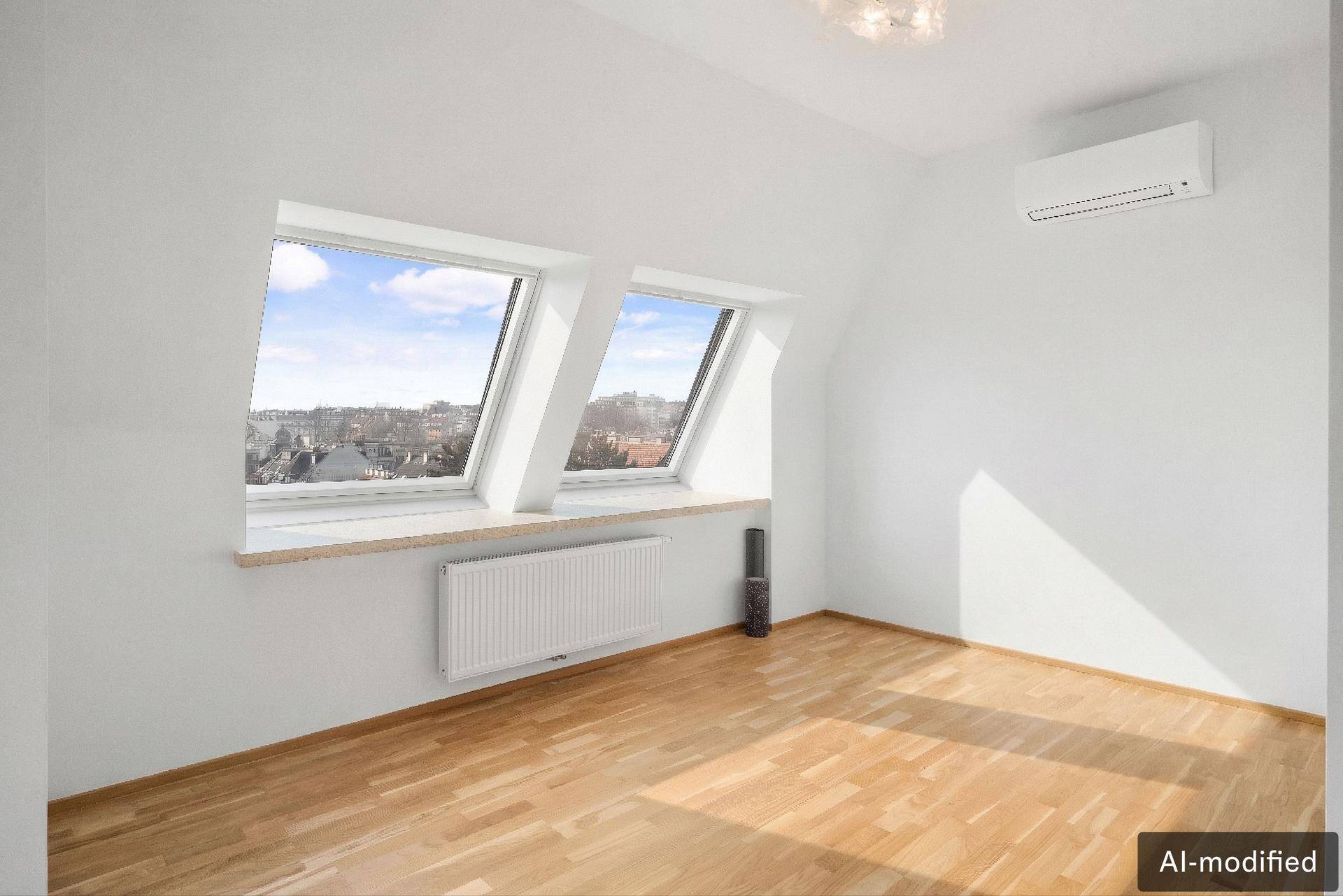 Leeres Schlafzimmer mit Holzboden, Dachfenstern und Heizkörper.