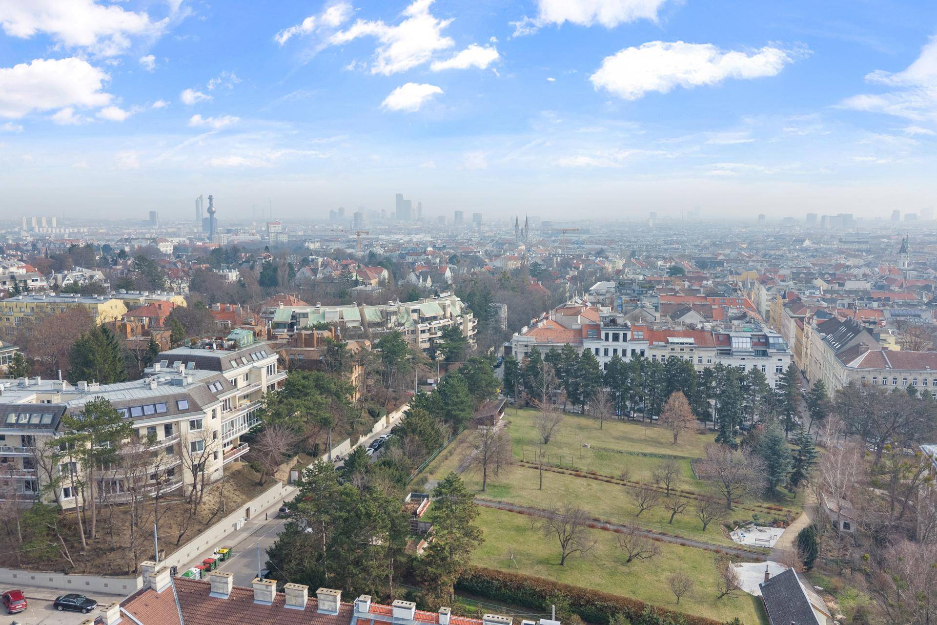 Weitläufige Luftaufnahme der Stadt mit Wohngebäuden und Grünflächen.