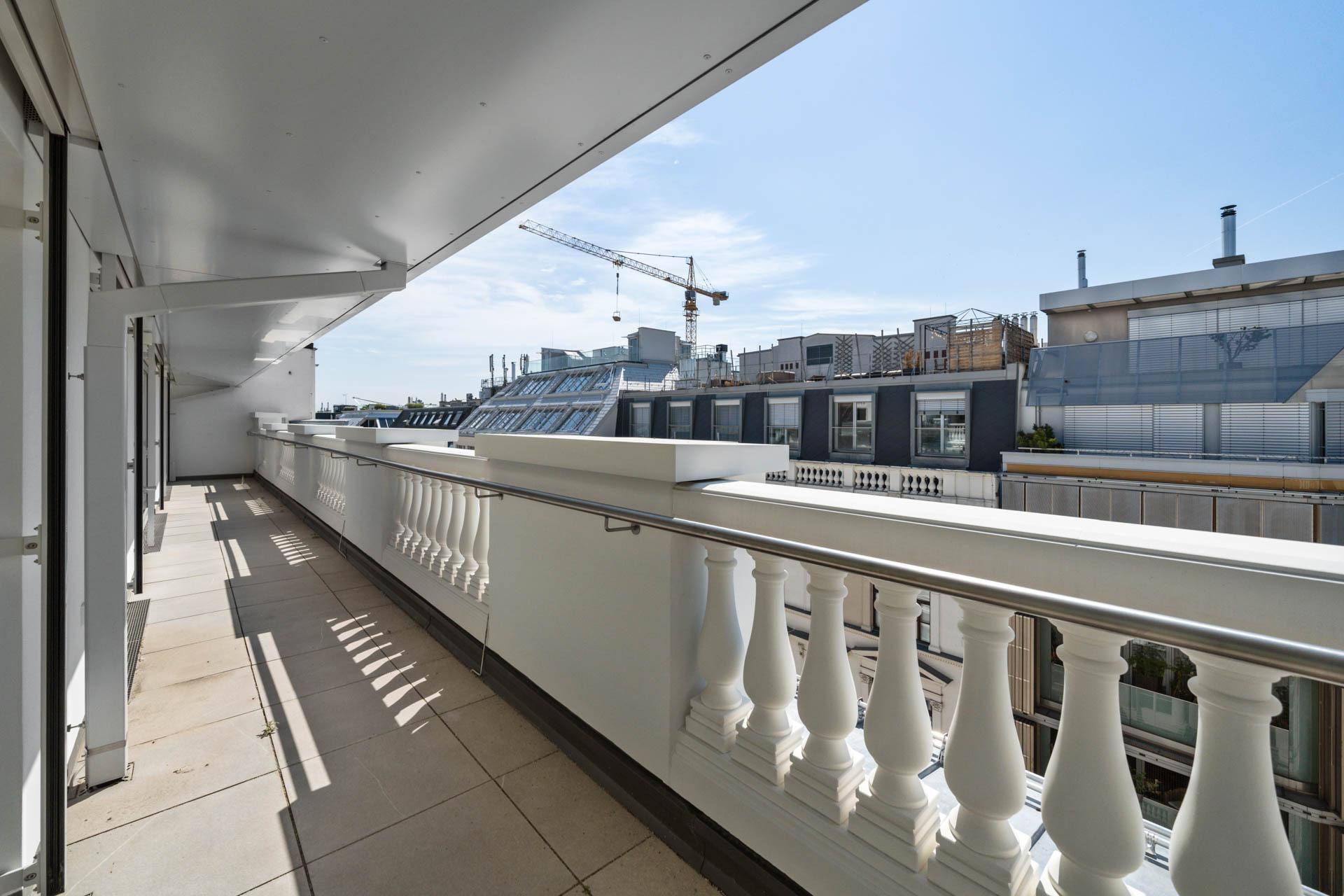 Langer Balkon mit klassischer Balustrade und Blick auf die umliegenden Gebäude.
