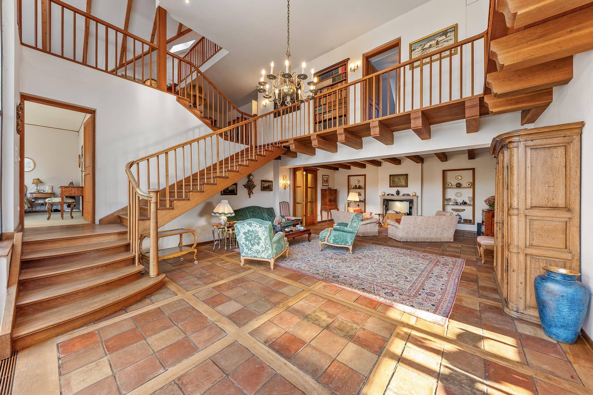 Repräsentativer Wohnbereich mit offener Galerie, Holztreppen und eleganten Möbeln.
