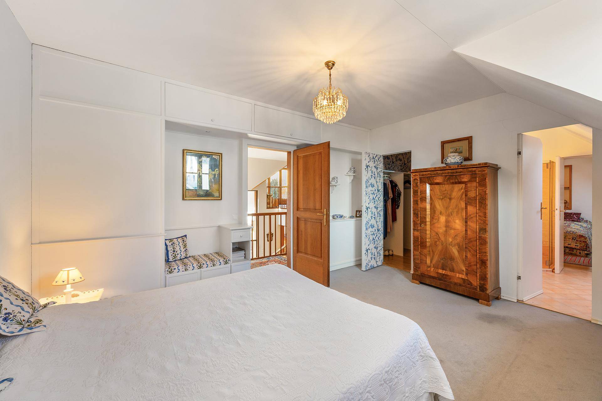 Helles Schlafzimmer mit Dachschräge, Einbauschränken und einem bequemen Doppelbett.