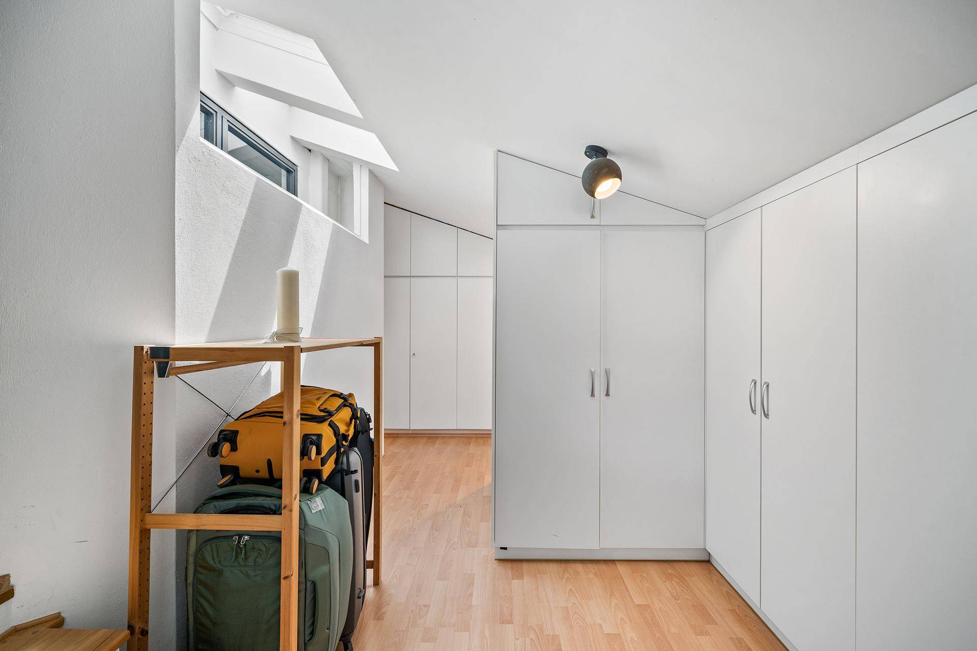 Heller Flur mit Einbauschränken und Dachfenster, ideal als Stauraum.