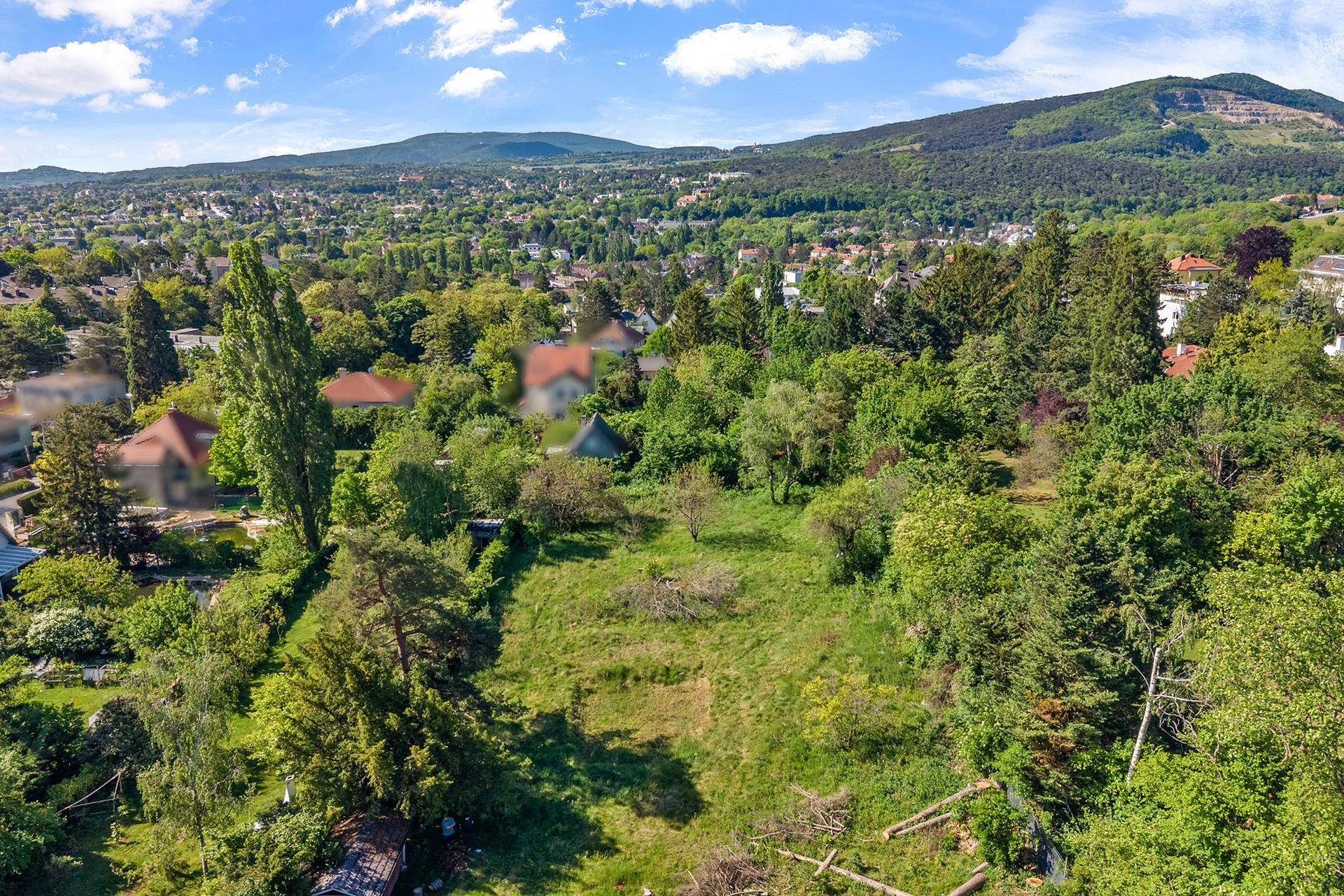 Luftbild des Grundstücks mit Blick auf die umliegende grüne Landschaft und ferne Berge.
