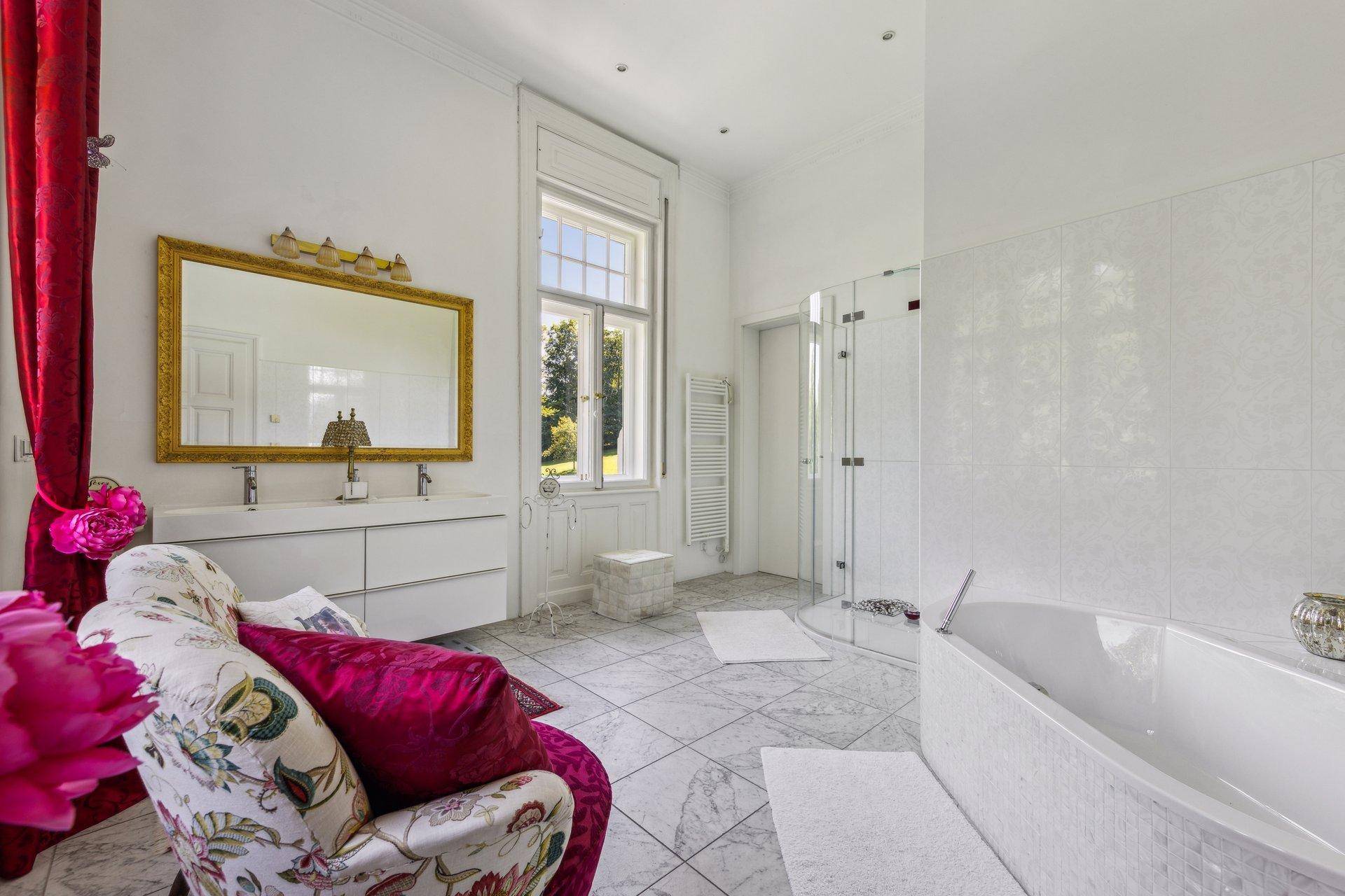 Geräumiges Badezimmer mit freistehender Badewanne, großer Dusche und Doppelwaschbecken.