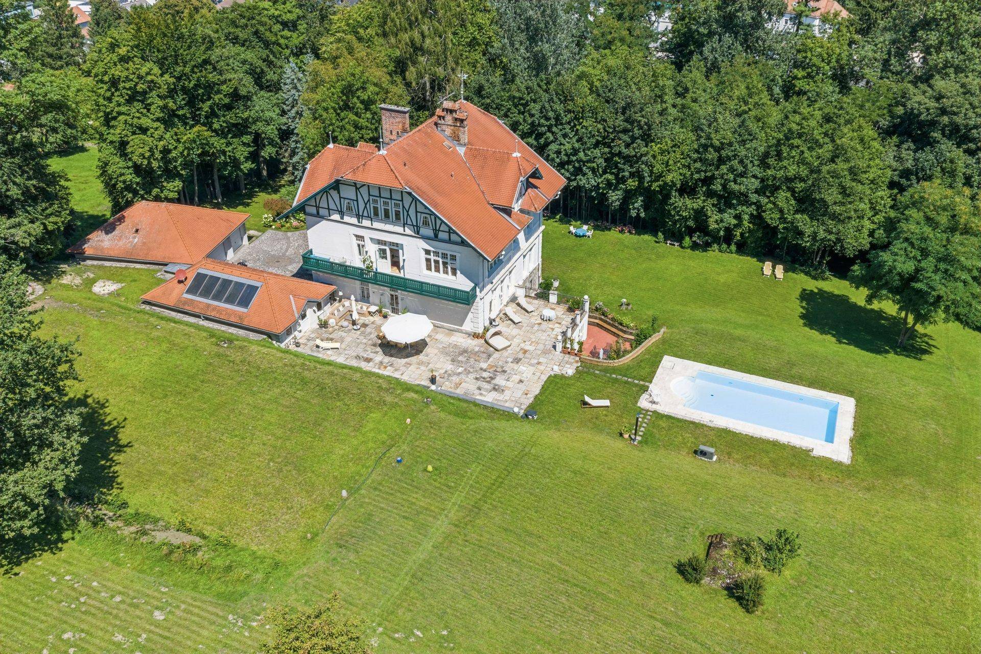 Luftaufnahme der historischen Villa mit großem Grundstück, Pool und umgebenden Bäumen.