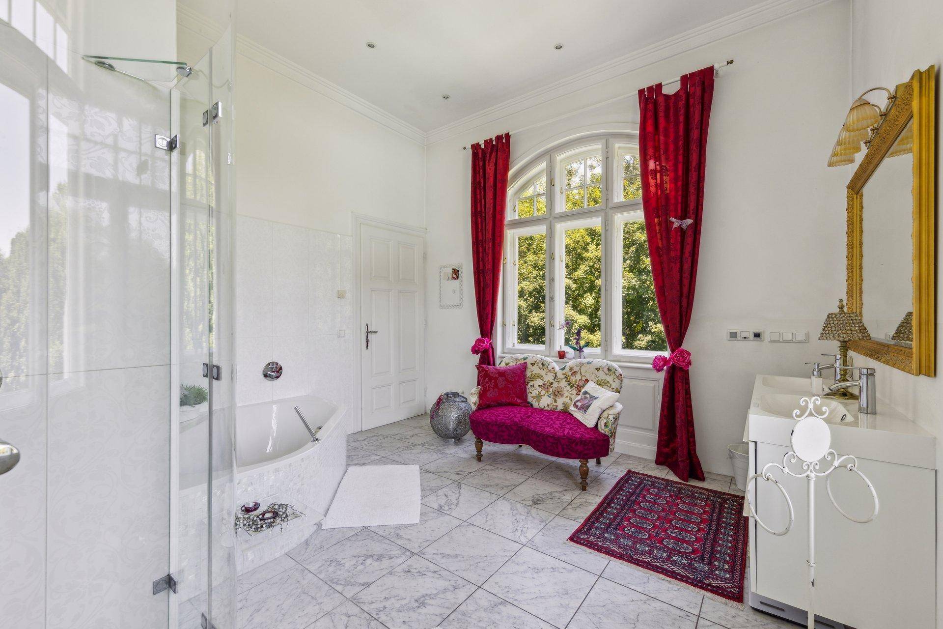 Luxuriöses Badezimmer mit großer Dusche, Badewanne und eleganten Marmorfliesen.