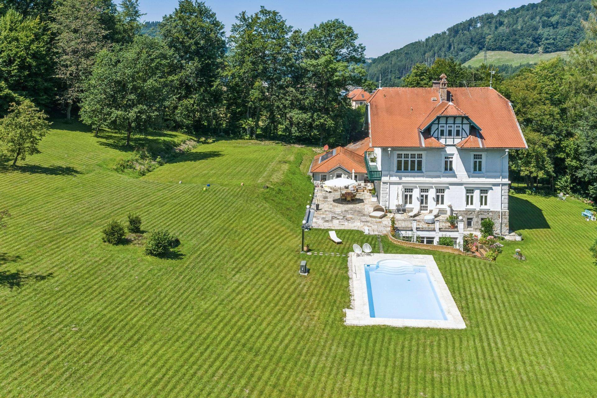 Panoramablick aus der Vogelperspektive auf die Villa mit Pool und weitläufigem Garten.