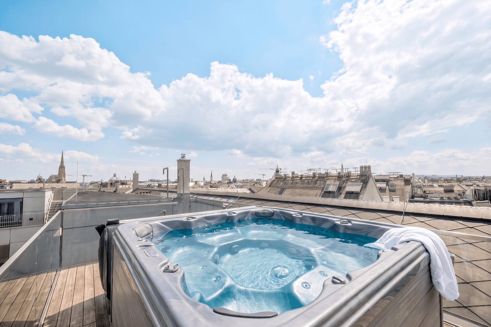 Dachterrasse mit Whirlpool und weitem Blick über die Dächer der Stadt.
