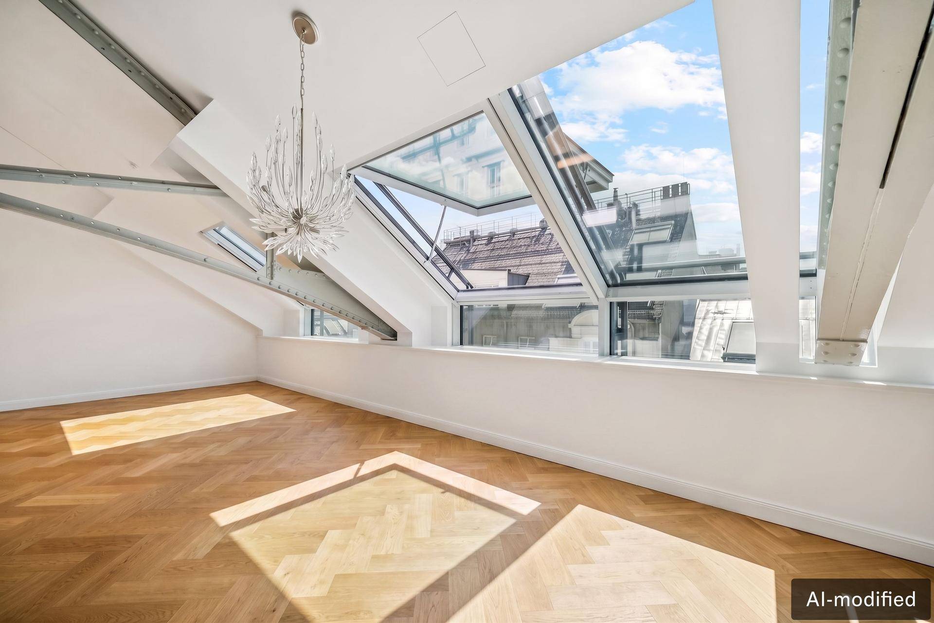 Heller Raum mit Holzboden, großen Dachfenstern und Blick auf die umliegenden Gebäude.