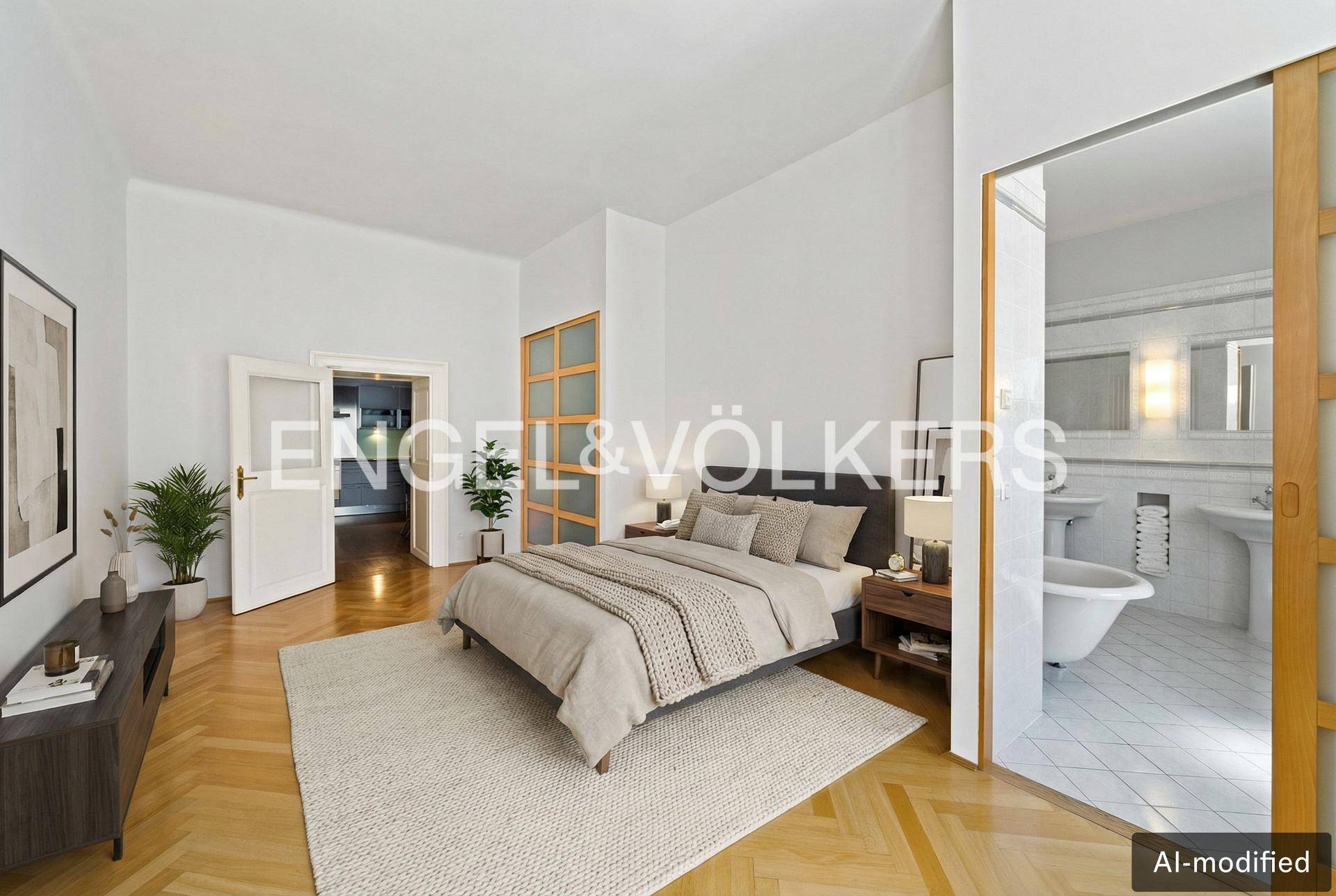 Helles Schlafzimmer mit Parkettboden und direktem Zugang zu einem Badezimmer mit freistehender Badewanne.