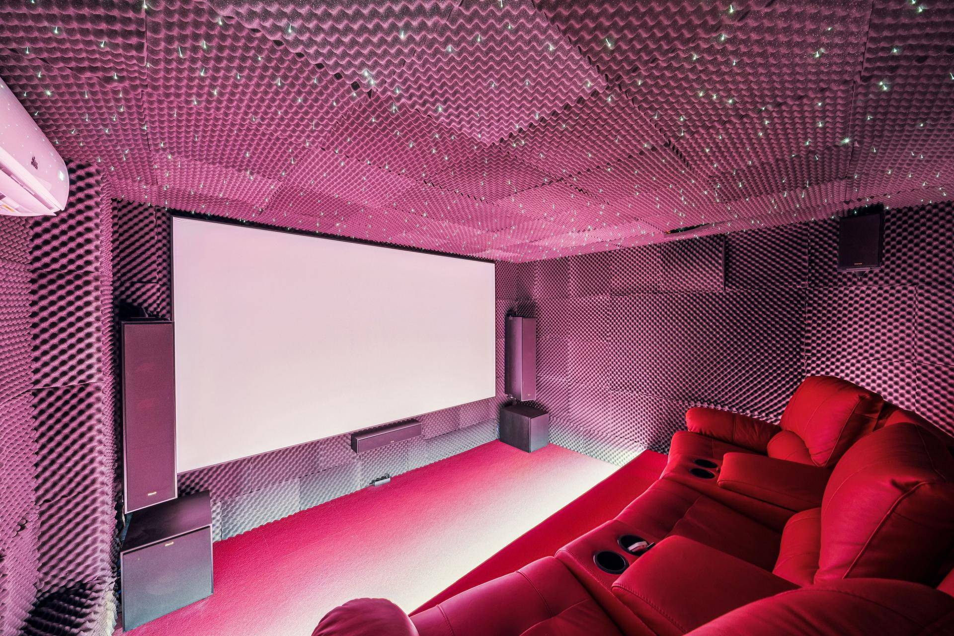 Exklusiver Heimkinoraum mit großer Leinwand, bequemen Sesseln und spezieller Akustik.