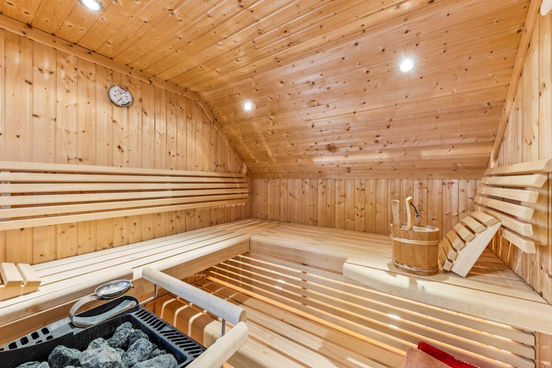 Traditionelle Holzsauna mit Bänken und Saunaofen, ideal für entspannende Momente.