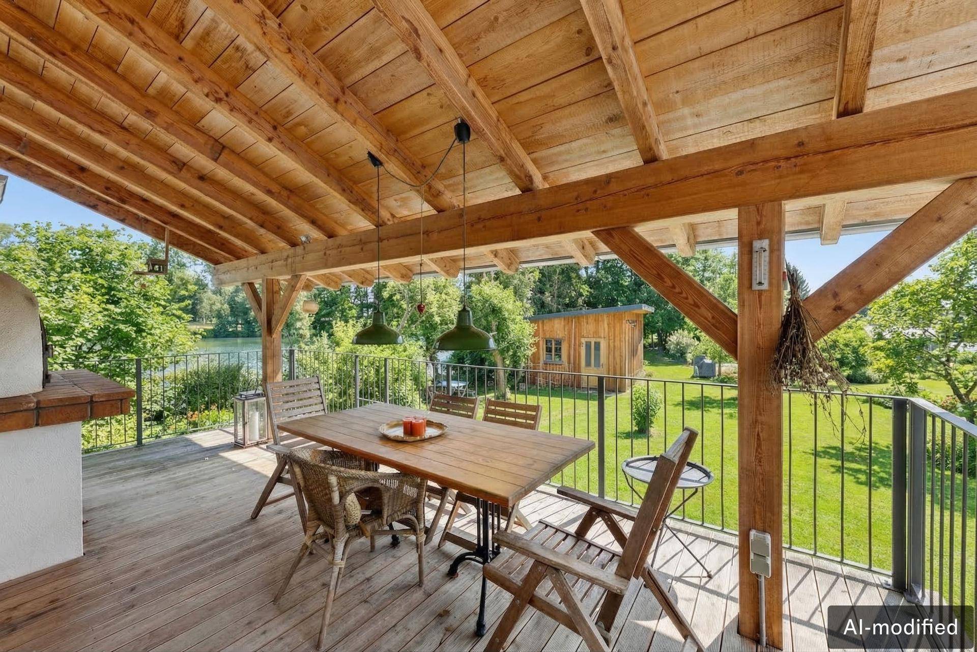 Überdachte Terrasse mit Holzboden, Esstisch und malerischem Blick auf den See.