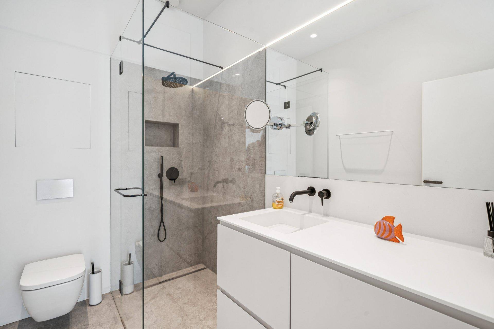 Modernes Badezimmer mit begehbarer Dusche, Wand-WC und großem Waschtisch.