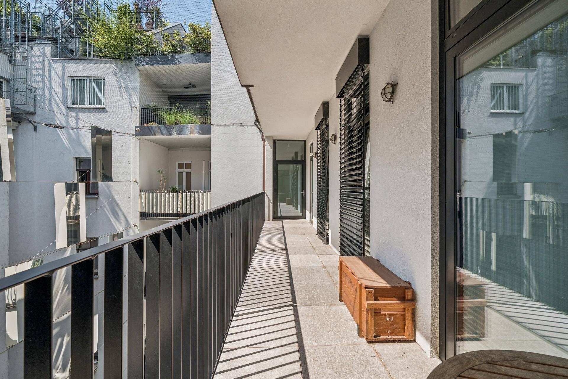 Langer Balkon mit Fliesenboden und Blick auf die umliegenden Gebäude.