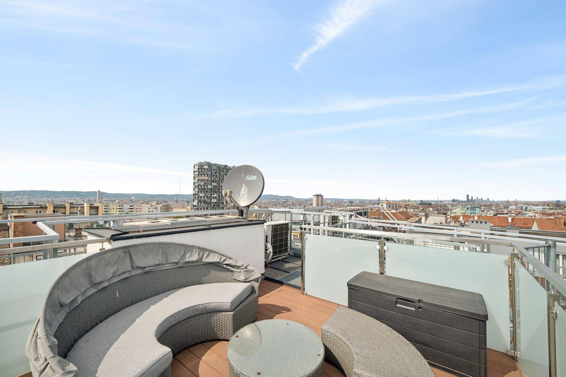 Geräumige Dachterrasse mit Lounge-Möbeln und weitem Blick über die Stadt.