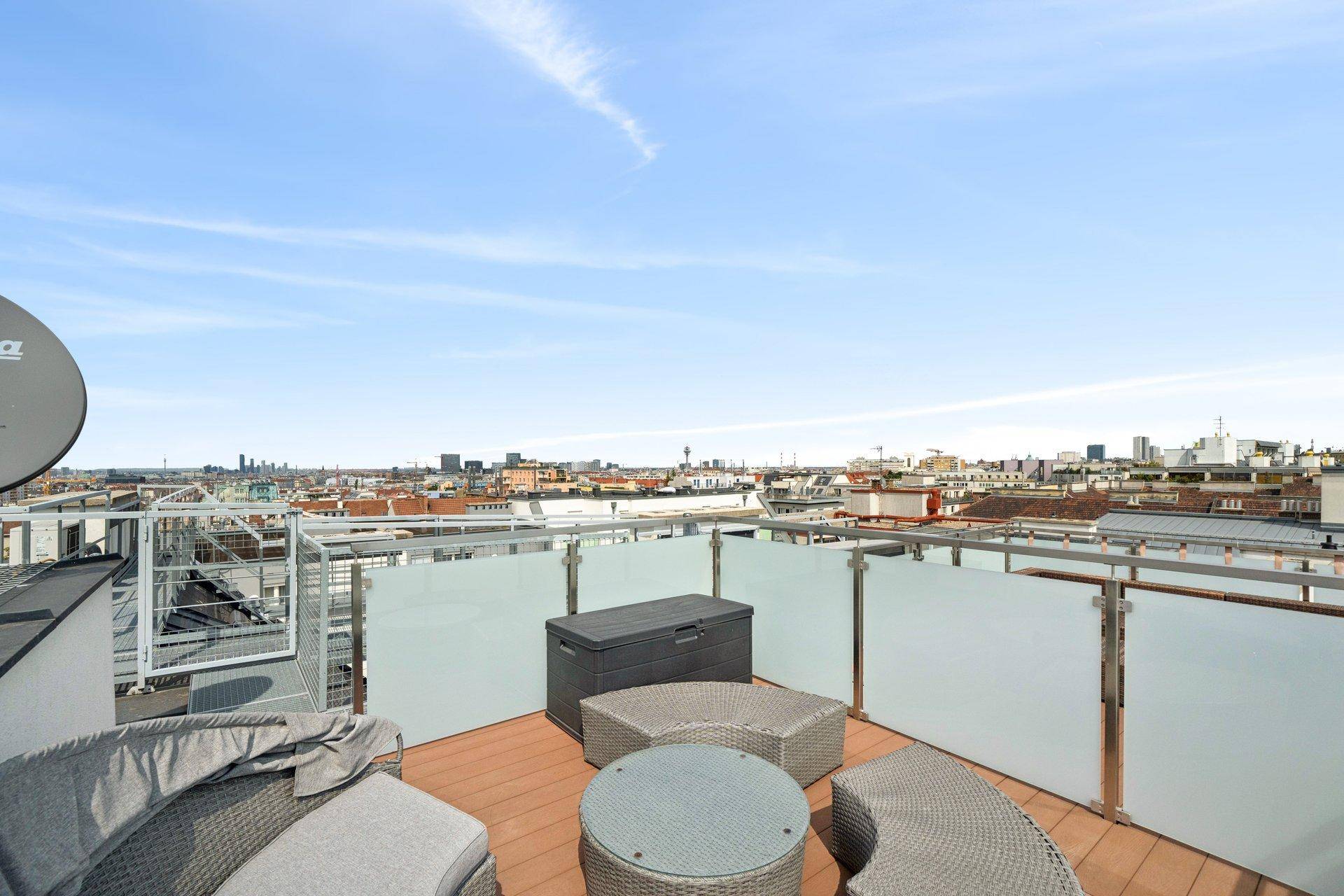 Weitläufige Dachterrasse mit moderner Verglasung und Panoramablick über die Stadt.