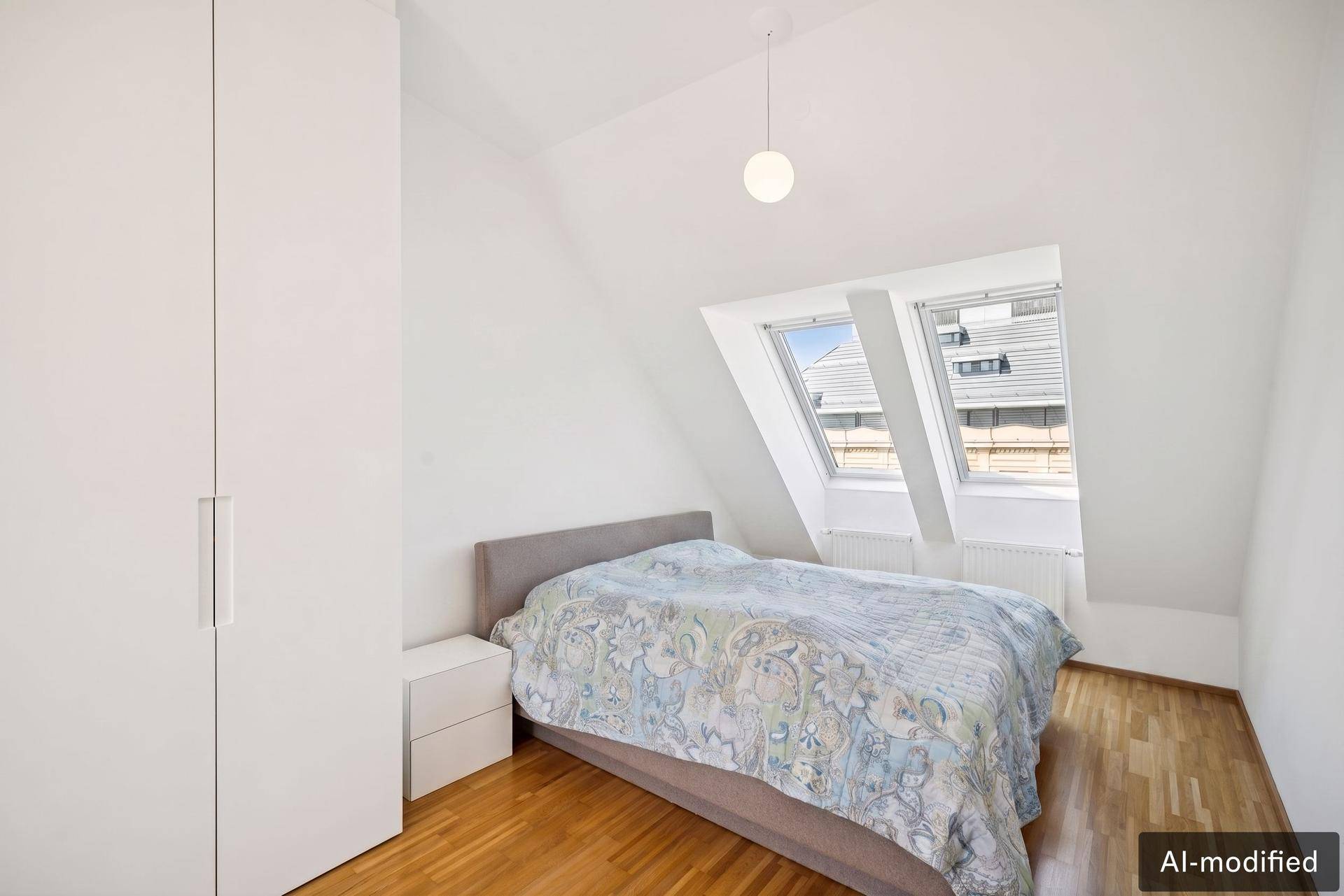 Gemütliches Schlafzimmer im Dachgeschoss mit Bett, Einbauschränken und zwei Dachfenstern.
