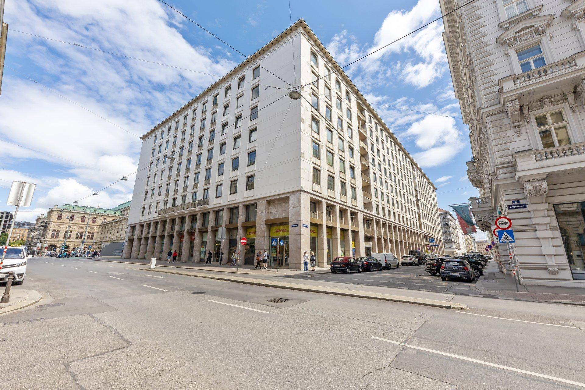 Großes Eckgebäude mit moderner Architektur und Geschäften im Erdgeschoss.