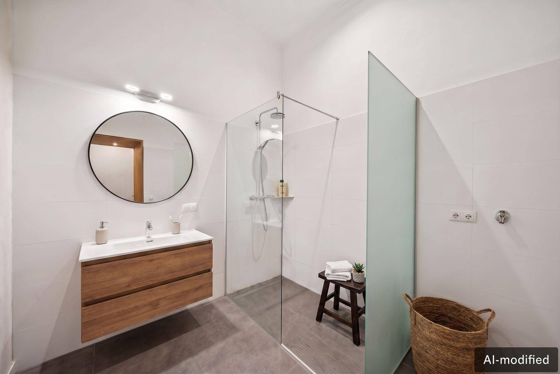 Modernes Badezimmer mit großer begehbarer Dusche, Holzwaschtisch und rundem Spiegel.
